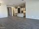 Open concept living room with gray tile floors and kitchen island at 15922 W Electra Ln, Surprise, AZ 85379
