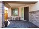 Covered porch with stone details and comfortable seating at 17663 W Straight Arrow Ln, Surprise, AZ 85387
