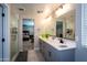 Modern bathroom with double vanity, large shower, and view of bedroom at 17663 W Straight Arrow Ln, Surprise, AZ 85387