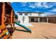 Backyard view of home with playset and basketball hoop at 17663 W Straight Arrow Ln, Surprise, AZ 85387