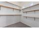 Large walk-in closet with wood shelves and hanging rods at 13222 W Indianola Ave, Litchfield Park, AZ 85340