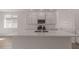 Modern kitchen with white cabinets, gas range and large island at 25227 N 131St Dr, Peoria, AZ 85383