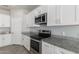 Kitchen with white cabinets, granite countertops, and stainless steel appliances at 9290 W Troy Dr, Arizona City, AZ 85123