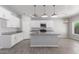 Open concept kitchen with island, white cabinets, and granite countertops at 9290 W Troy Dr, Arizona City, AZ 85123