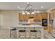Kitchen with an island, light wood cabinets, and stainless steel appliances at 42929 W Castle Cove Cir, Maricopa, AZ 85138
