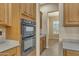 Kitchen features double ovens and ample wood cabinets at 42929 W Castle Cove Cir, Maricopa, AZ 85138