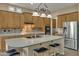 Kitchen island with seating, wood cabinets, and stainless steel appliances at 42929 W Castle Cove Cir, Maricopa, AZ 85138