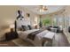 Main bedroom with king-size bed and sitting area, offering natural light at 42929 W Castle Cove Cir, Maricopa, AZ 85138