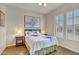 Bright bedroom with a queen-size bed, nightstands, and large windows at 42929 W Castle Cove Cir, Maricopa, AZ 85138