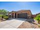 Well maintained house with a two-car garage and attractive desert landscaping at 42057 W Manderas Ln, Maricopa, AZ 85138