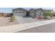 Two-car garage and landscaped front yard with roses at 22207 N Daniel Dr, Maricopa, AZ 85138