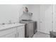 Bright laundry room, washer, dryer, and cabinets at 22207 N Daniel Dr, Maricopa, AZ 85138