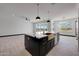 Open concept kitchen with large island, stainless steel appliances, and modern lighting at 31214 N 167Th Ave, Surprise, AZ 85387