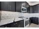 Stylish kitchen with dark cabinetry, marble countertops, and a built-in microwave at 31214 N 167Th Ave, Surprise, AZ 85387