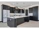 Spacious kitchen featuring dark cabinetry, marble countertops and large island at 31214 N 167Th Ave, Surprise, AZ 85387