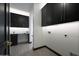 Laundry room with black cabinets, quartz countertop, and under-cabinet lighting at 31214 N 167Th Ave, Surprise, AZ 85387