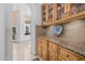 Butlers pantry with granite countertops, wood cabinets, and glass-front shelving at 6620 E Stallion Rd, Paradise Valley, AZ 85253