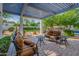Relaxing patio with covered seating area, lush landscaping, and a view of the pool at 6620 E Stallion Rd, Paradise Valley, AZ 85253