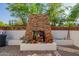 Stone outdoor fireplace with seating and potted plants at 6620 E Stallion Rd, Paradise Valley, AZ 85253