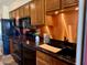 Kitchen with dark wood cabinets, copper backsplash and modern appliances at 1844 W Virginia Ave, Phoenix, AZ 85007