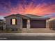 Attractive single-story home with a brown garage door and nicely landscaped yard at dusk at 4693 N 177Th Ln, Goodyear, AZ 85395