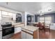 Open concept kitchen and dining area with wood flooring and a ceiling fan at 11836 W Roanoke Ave, Avondale, AZ 85392