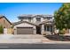 Two-story house with solar panels, brown garage door, and stone accents at 1264 E Walnut Rd, Gilbert, AZ 85298