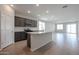 Modern kitchen with dark gray cabinets, granite countertops, and island at 40040 W Bravo Dr, Maricopa, AZ 85138