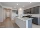 Modern kitchen with dark gray cabinets, granite countertops and island at 40040 W Bravo Dr, Maricopa, AZ 85138