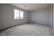 Bright bedroom with neutral carpeting and large window at 40040 W Bravo Dr, Maricopa, AZ 85138