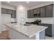Modern kitchen with dark gray cabinets, granite countertops and island at 40040 W Bravo Dr, Maricopa, AZ 85138