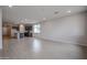 Spacious living area with tile floors and kitchen access at 40040 W Bravo Dr, Maricopa, AZ 85138