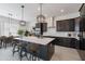 Modern kitchen with dark cabinetry, large island, and stainless steel appliances at 18083 W Amber Dr, Goodyear, AZ 85338