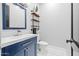 Modern bathroom with a navy blue vanity and floating shelves at 17617 W Rose Ln, Waddell, AZ 85355