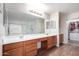 Double vanity bathroom with wood cabinets and a large mirror at 16079 W Williams St, Goodyear, AZ 85338