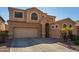 Two-story house with tan exterior, a three-car garage, and palm trees at 16079 W Williams St, Goodyear, AZ 85338