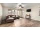 Living room with L-shaped sofa, hardwood floors, and large windows at 16079 W Williams St, Goodyear, AZ 85338