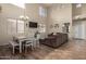 Spacious living room with hardwood floors, a dining area, and a large TV at 16079 W Williams St, Goodyear, AZ 85338