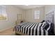 Striped bedding and a stylish headboard in this well-lit bedroom at 4517 W Lodge Dr, Laveen, AZ 85339