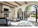 Cozy sitting area with fireplace and arched doors leading to a patio at 10493 E Rimrock Dr, Scottsdale, AZ 85255