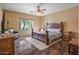 Main bedroom with wood flooring, ceiling fan, and a large bed at 11110 N 165Th Ave, Surprise, AZ 85388