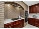 Granite countertop kitchen with dark wood cabinets and brick accent wall at 39839 N Spur Cross Rd, Cave Creek, AZ 85331