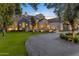 Beautiful home with stone and shingle exterior, well-manicured lawn, and a circular driveway at 20445 E Sunset Ct, Queen Creek, AZ 85142