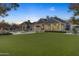 Expansive backyard with a large pool, lush lawn, and covered patio area at 20445 E Sunset Ct, Queen Creek, AZ 85142