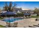 Inviting pool area with spacious patio, lounge chairs, and multiple umbrellas at 20445 E Sunset Ct, Queen Creek, AZ 85142