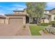 Two-story home with tan exterior, landscaping, and a three-car garage at 3424 E Plum St, Gilbert, AZ 85298