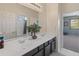 Bathroom with dark vanity, double sinks, and a view of a bedroom at 3331 W Hemingway Ln, Anthem, AZ 85086