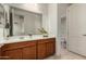 Clean bathroom with double vanity, brown cabinets, and a separate toilet area at 23095 E Mewes Rd, Queen Creek, AZ 85142
