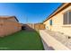 Side yard with grassy area and pathway to gate at 17523 W Fetlock Trl, Surprise, AZ 85387