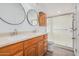 Bathroom with double sinks, wood cabinets, and a shower at 2650 W Union Hills Dr # 54, Phoenix, AZ 85027